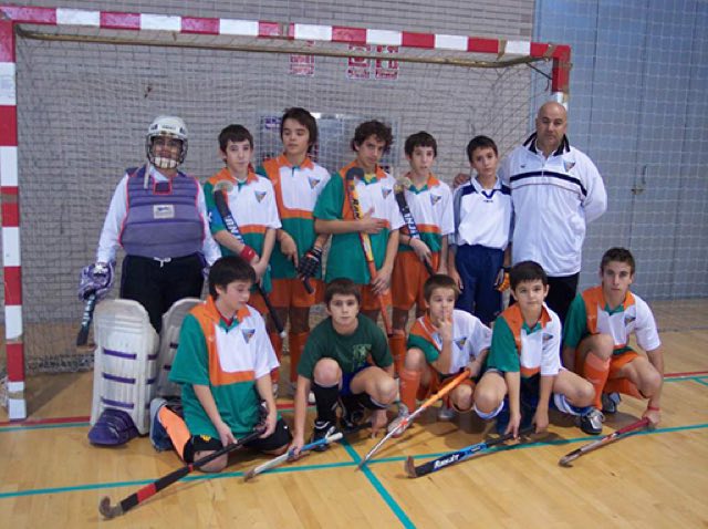 Equipo infantil del club posando en el pabellón con sus sticks